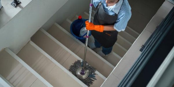 cleaning-woman-is-standing-inside-building-holding-with-blue-tank-side-facilities-tidying-up-her-hand_931309-4571