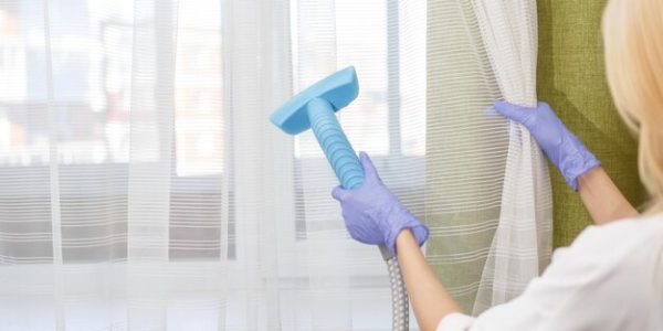 girl-holds-steamer-curtains-her-hand-cleaning-apartment_553815-379