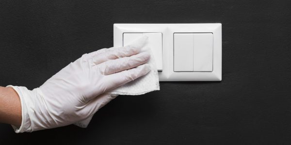 hand-with-glove-disinfecting-light-switches
