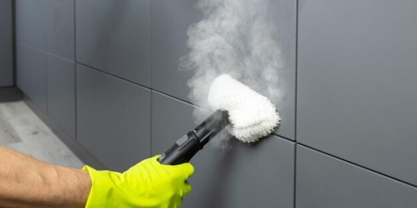mans-hand-protective-glove-cleans-kitchen-facade-with-steam_182033-212