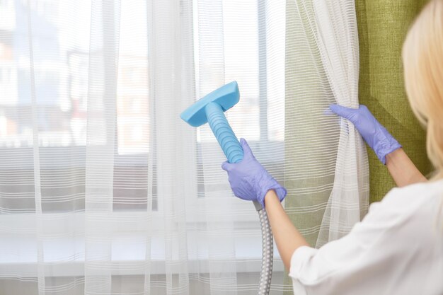 girl-holds-steamer-curtains-her-hand-cleaning-apartment_553815-379
