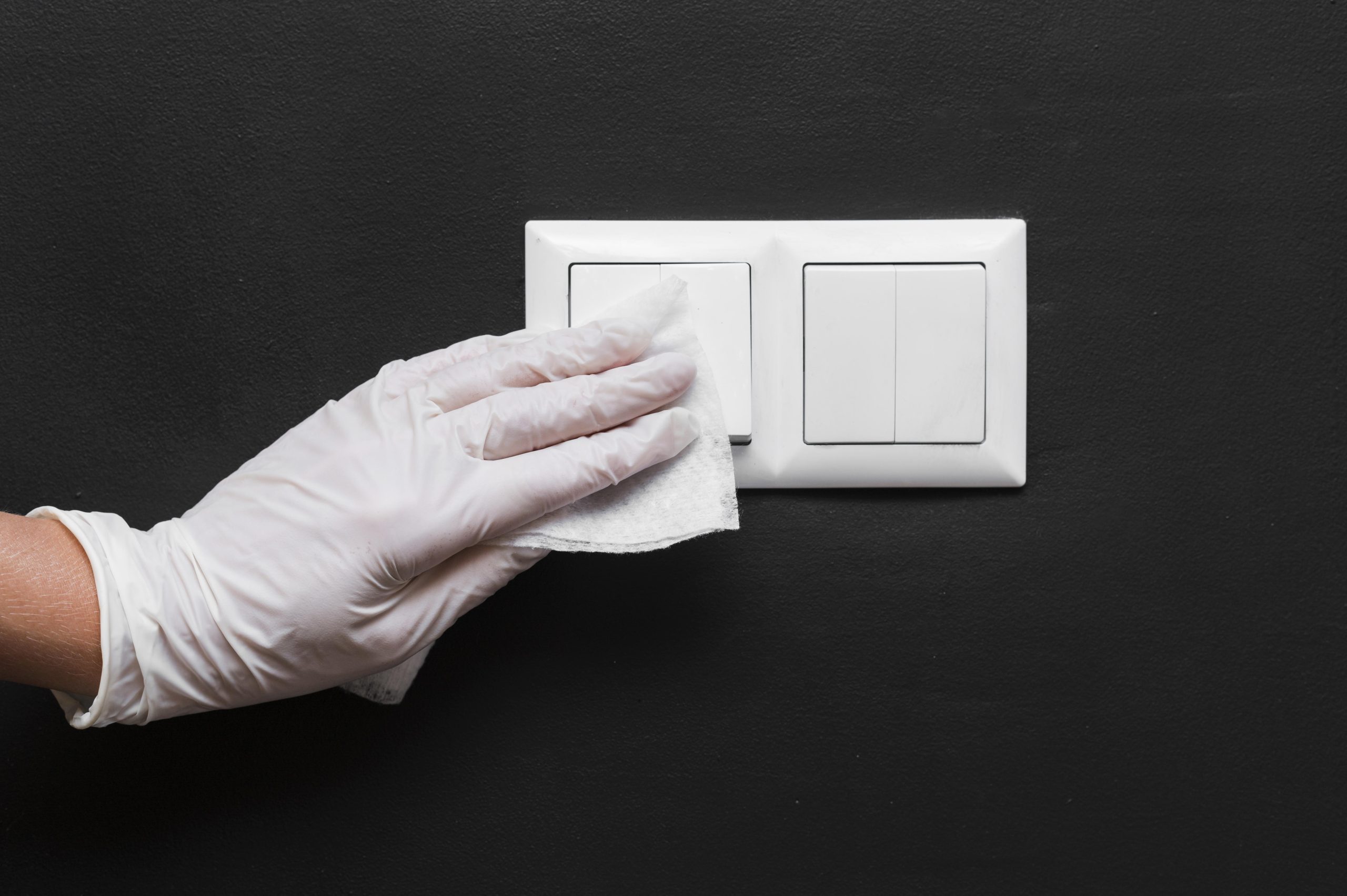 hand-with-glove-disinfecting-light-switches