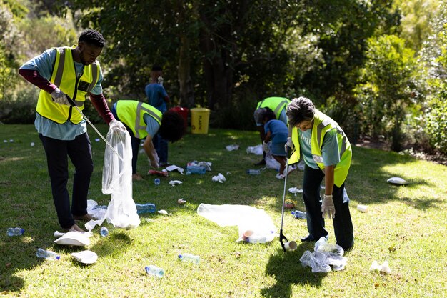 multi-generation-mixed-race-family-spending-time-outside-together-all-wearing-blue-volunteer-t-shirts-protective-gloves-collecting-garbage-holding-garbage-bags-sunny-day_13339-305383