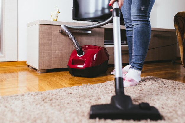 young-woman-cleaning-house-with-vacuum-cleaner_473712-485